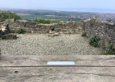 The location of the metal plaque on the bench.